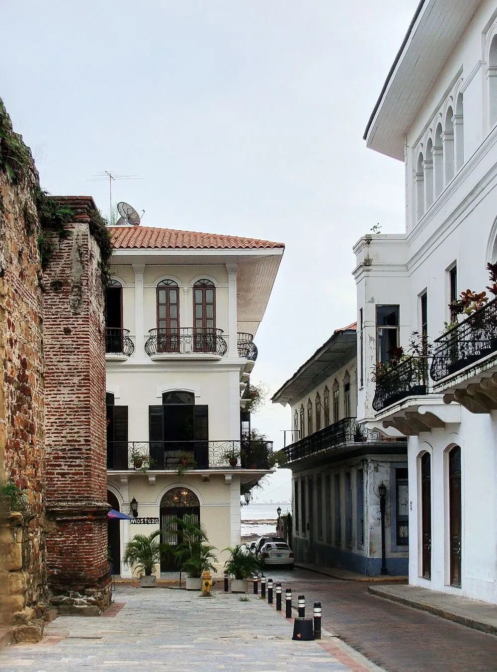A street in Casco Antiguo with white colonial houses, iron balconies and a stone wall