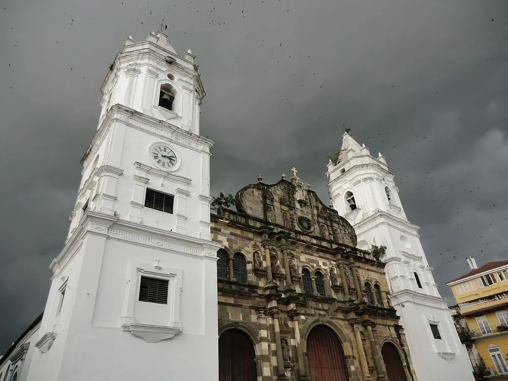 The two white towers of Panama's Metropolitan Cathedral under a cloudy sky